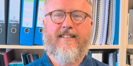 Prof. Dr. Michael Becker steht vor einem Bücherregal im Institut für Schulentwicklungsforschung