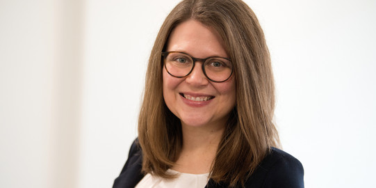 Porträtfoto von Justine Stang-Rabrig vor einem hellen Hintergrund