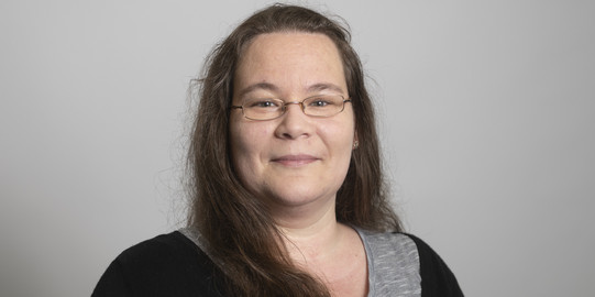 Sabrina König Sabrina König steht vor einem grauen Hintergrund