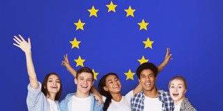 Fünf Jugendliche lächeln in die Kamera vor der europäischen Flagge