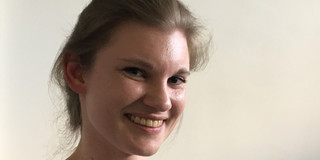 Manuela Endberg steht vor einer weißen Wand