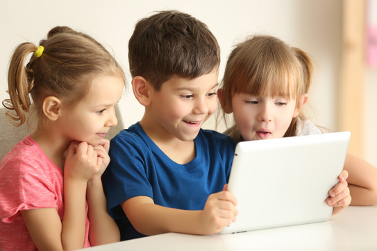 Kinder am Tablet Drei Kinder sehen sich ein Tablet an
