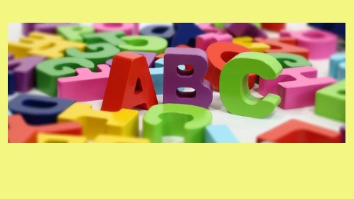 Gelber Hintergrund und Foto von bunten Buchstaben mit dem schwarzen Schriftzug "Motivation, Lesen und Geschlecht, Ergebnisse aus IGLU 2016".