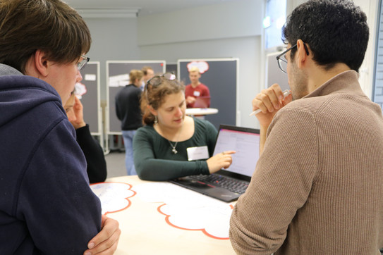 Teilnehmende des Workshops unterhalten sich am Tisch