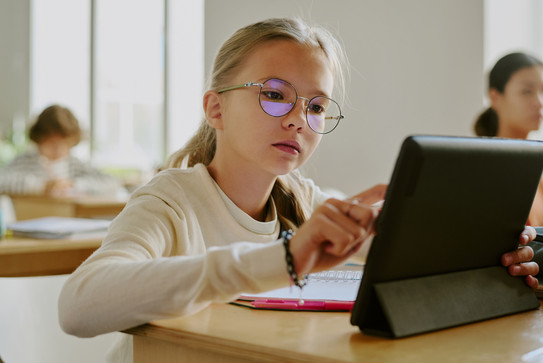 Schulunterricht Mädchen arbeitet im Unterricht am Tablet.