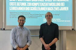 Foto von Prof. Andreas Dengel (links) und Dr. Sebastian Vogel (rechts) vor der Titelfolie seiner Präsentation