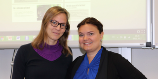 Professorin Nele McElvany und Professorin Heidi Harju-Luukkainen stehen vor einer Präsentation