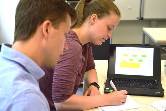Zwei Personen bei der Arbeit am Laptop