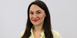 Porträtfoto von Olena Kryshko vor einem hellgrauen Hintergrund
