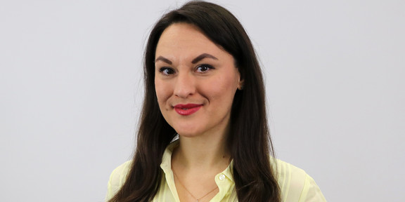 Porträtfoto von Olena Kryshko vor einem hellgrauen Hintergrund