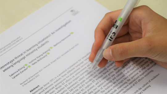 Hand mit IFS-Kugelschreiber, die etwas in einem Text markiert
