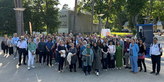 Gruppenfoto der teilnehmenden Wissenschaftlerinnen und Wissenschaftler vor Bäumen an einem sonnigen Tag