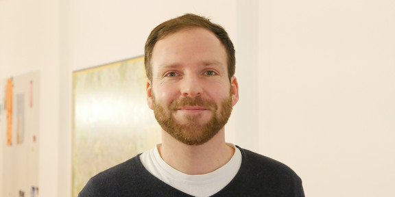Norbert Sendzik steht vor einer Wand im IFS