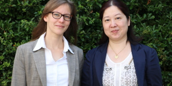 Nele McElvany und Frau Hua stehen vor einer Hecke