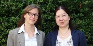 Nele McElvany und Frau Hua stehen vor einer Hecke