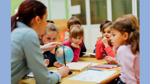 Blauer Hintergrund mit schwarzen Schriftzug "Lehrercommitment, Wie verbunden fühlen sich Lehrkräfte gegenüber Schule und Kollegium?" mit darunterliegenden Foto einer Lehrerin und einer Gruppe aus Grundschulkindern im Klassenraum.