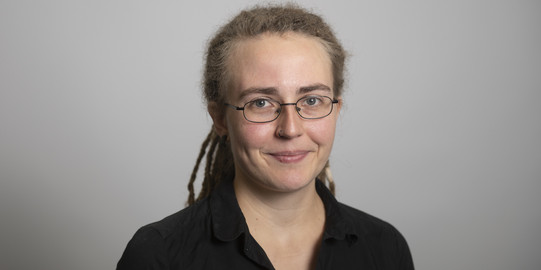Porträtfoto von Katharina Molitor vor einem grauen Hintergrund