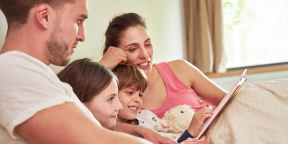 Vorlesen Eine Familie liest gemeinsam ein Buch.