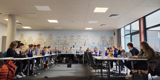 Die Mitglieder der Arbeitsgruppe arbeiten intensiv an Laptops in einem Seminarraum