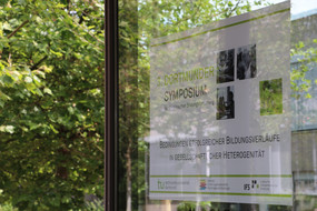 Foto des Posters zum 3. Dortmunder Symposium der empirischen Bildungsforschung mit grünen Bäumen im Hintergrund