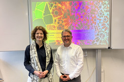 Julia Dietrich steht neben Alexander Naumann und lächelt zur Kamera.