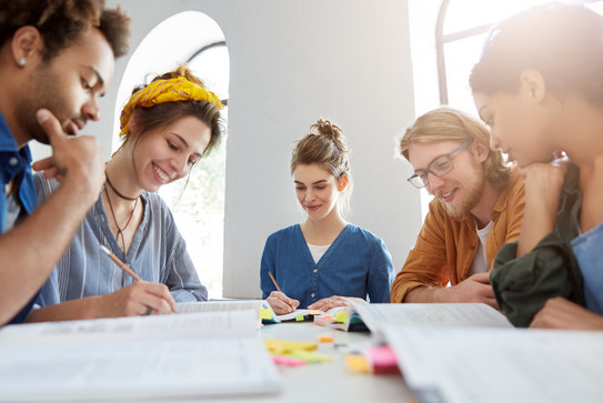 Gruppenarbeit Jugendliche Junge Erwachsene lernen gemeinsam an einem Tisch