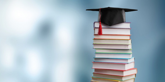 Doktorhut Ein bunter Bücherstapel mit einem Doktorhut