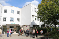 Foto des CDI-Gebäudes mit Veranstaltungsteilnehmenden und bei sonnigen Wetter