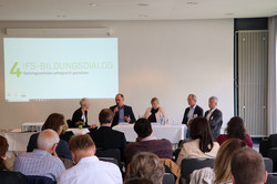 Foto der Podiumsdiskussion mit der Rückenansichts des Plenums