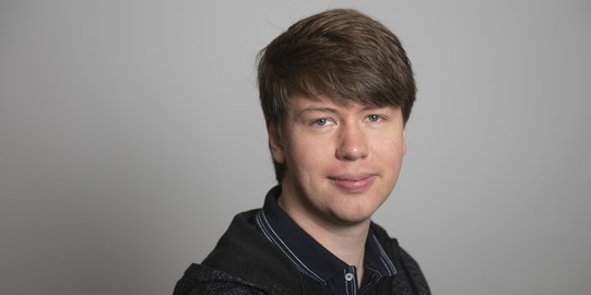 Thomas Brüggemann vor einem grauen Hintergrund