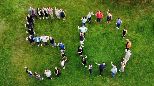 Mitarbeitende des IFS bilden gemeinsam die Zahl 50 auf einer Wiese