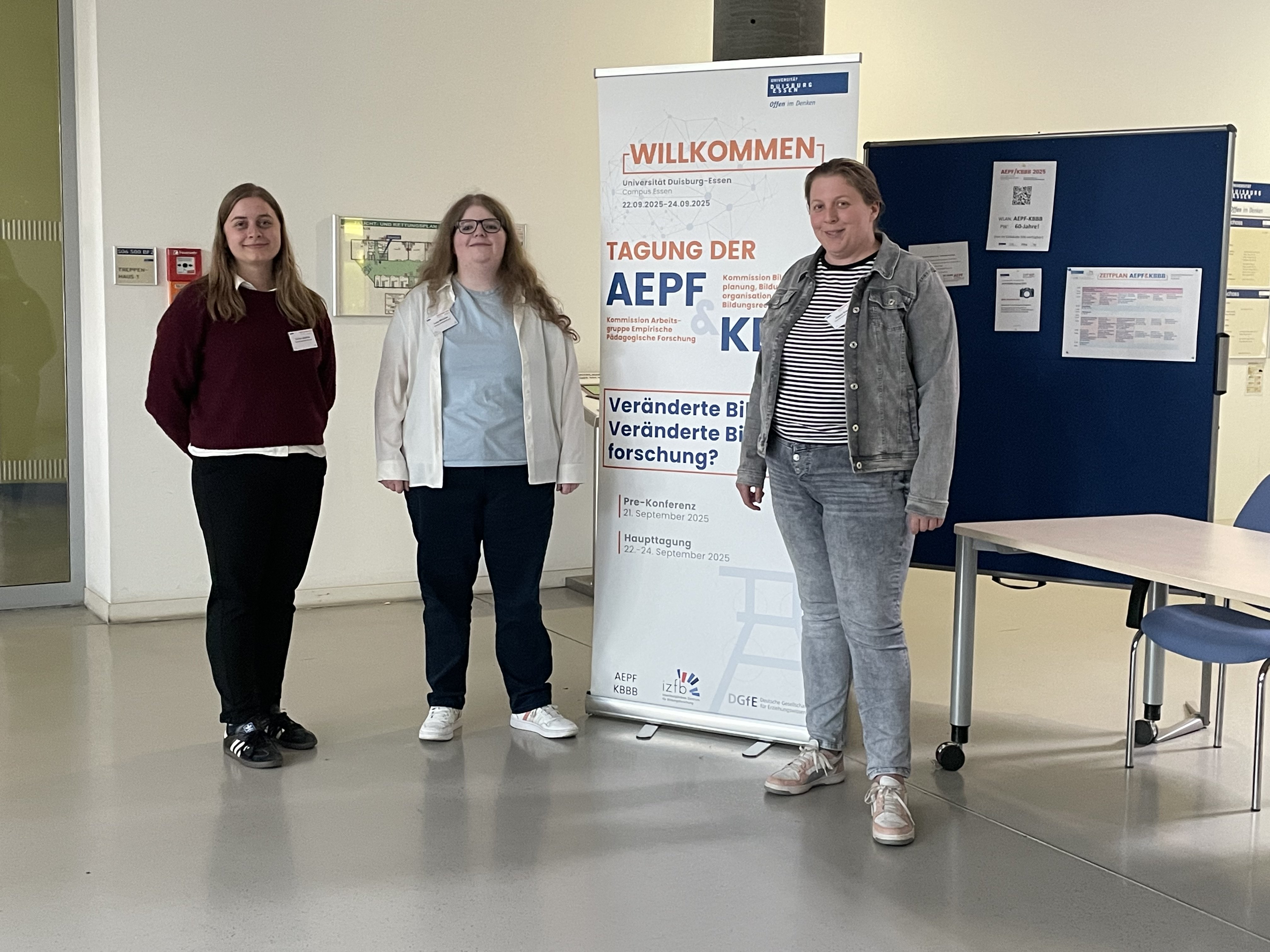 Carina Jüschke, Luisa Mörchen und Alyssa Grecu stehen neben einem Poster der AEPF